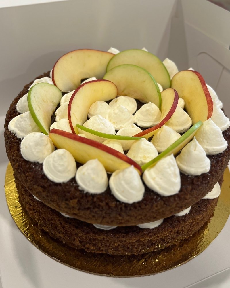 Carrot cake, layered and topped with cream and fruit