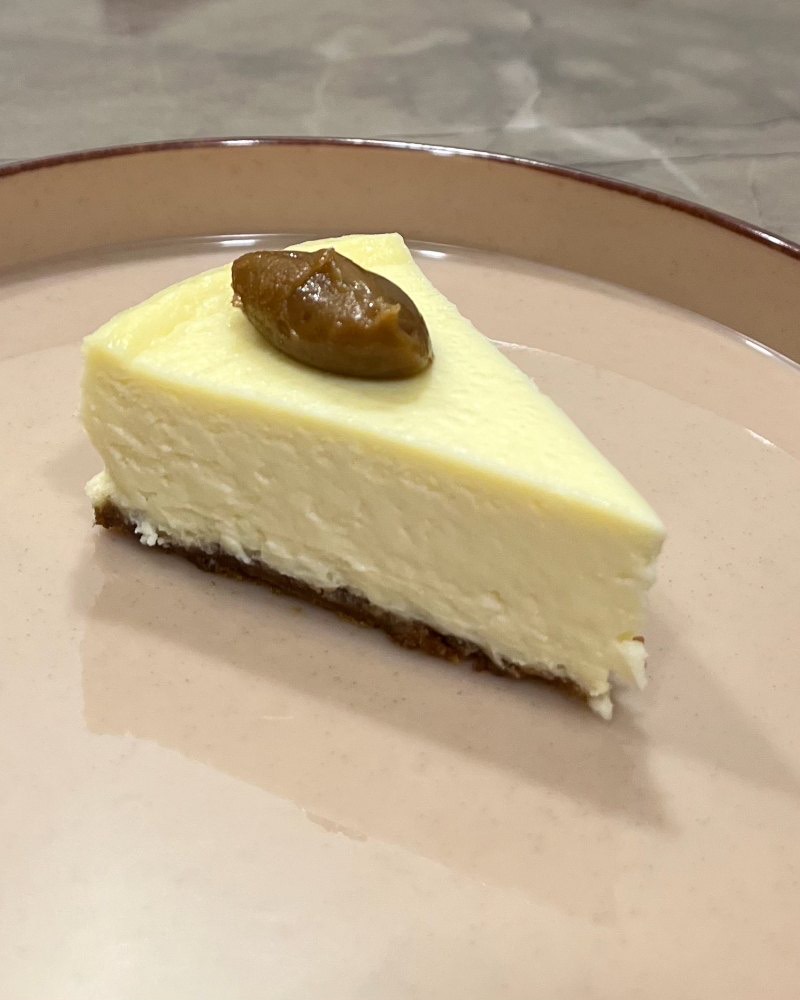 A slice of New York style cheesecake on a plate