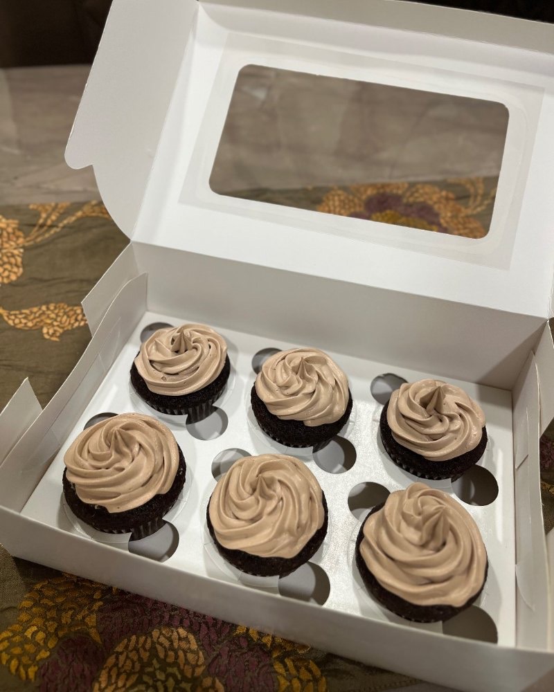 A boxed half dozen of whipped ganache cupcakes