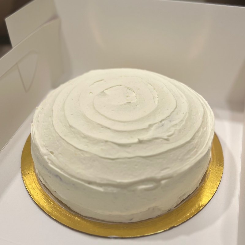 A whole frosted cake, boxed and ready to go